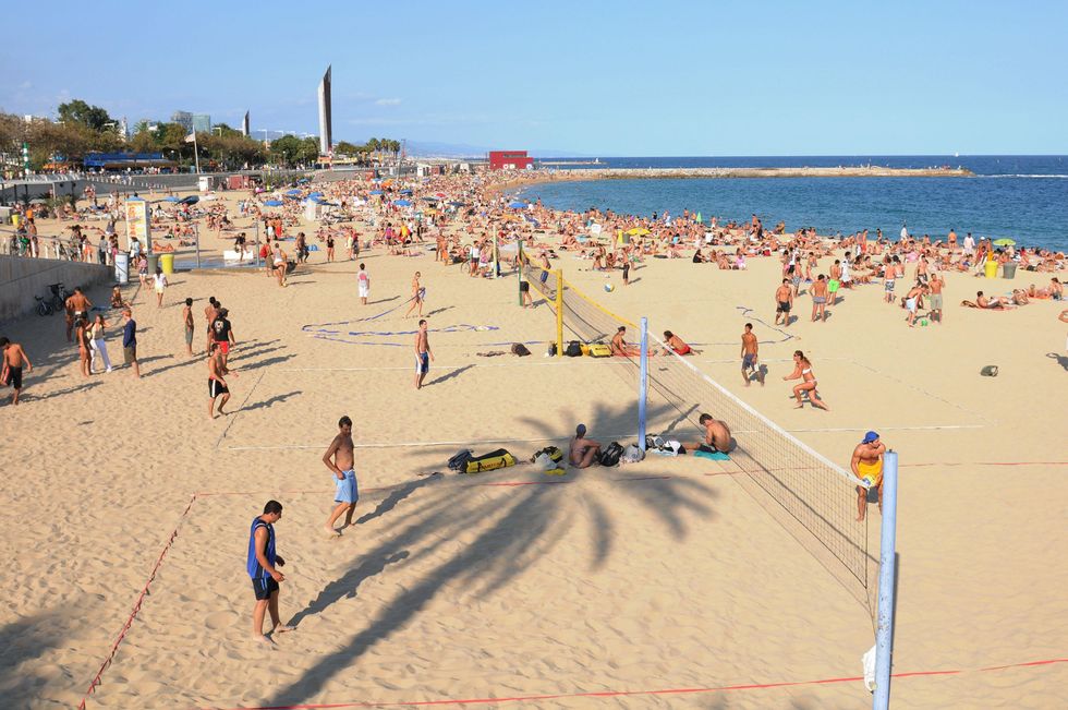 Holiday makers playing volley ball on a beach