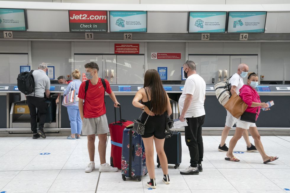 Holidaymakers catching flights to Palma and Tenerife at the Jet2 check-in desk at Glasgow Airport in Paisley