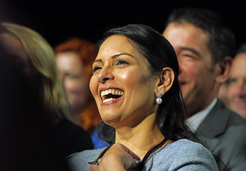 Home Secretary Priti Patel watches as Prime Minister Boris Johnson delivers his keynote speech at the Conservative Party Conference in Manchester.