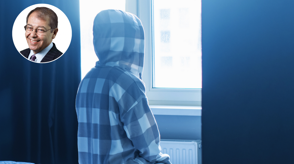 Hooded person looking out the window