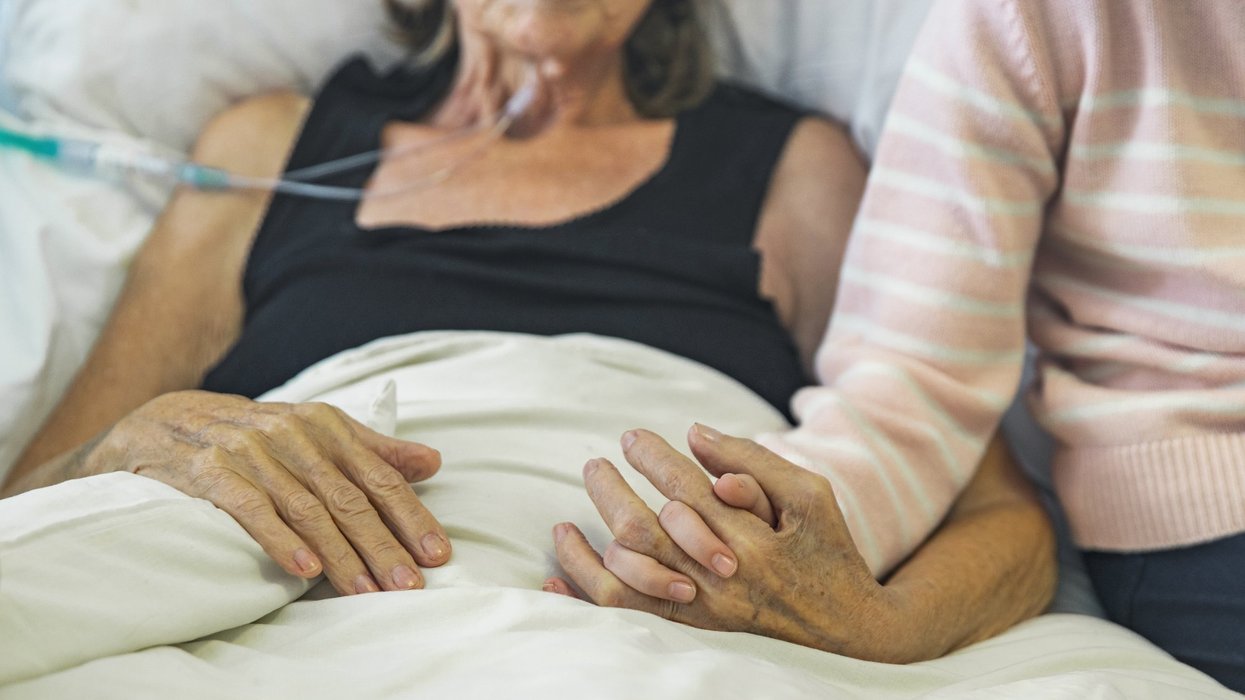 Hospice patient's hand held by loved one