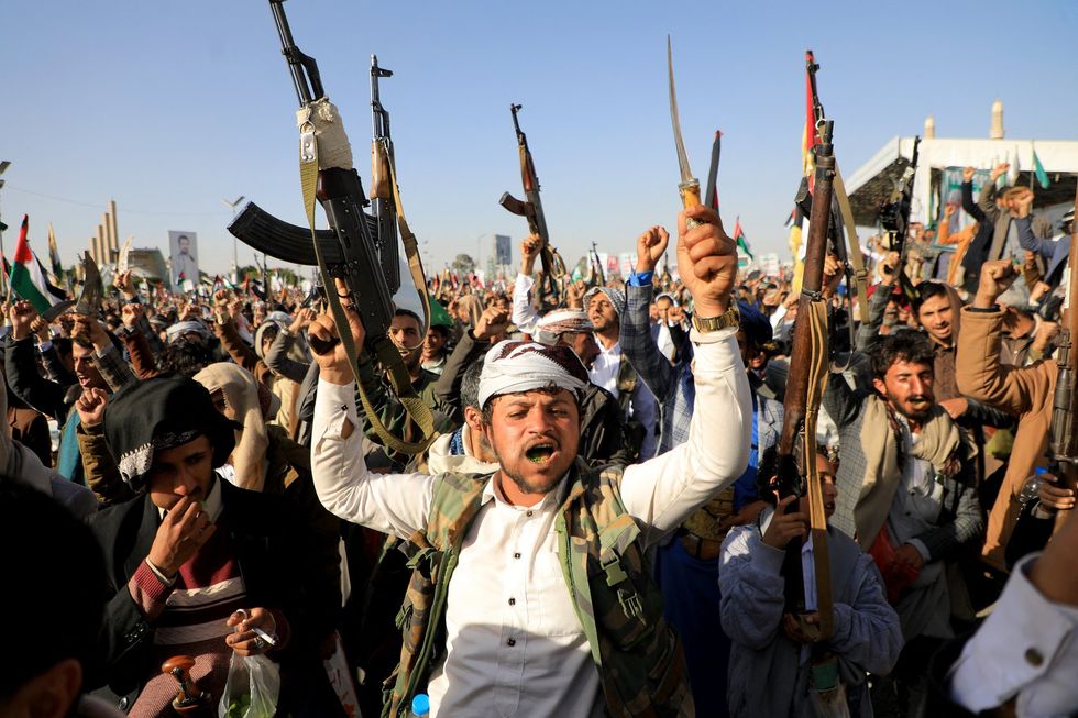 Houthi fighters celebrate with weapons drawn