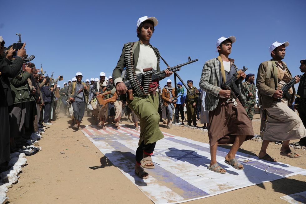 Houthi fighters stomping on US and Israeli flags