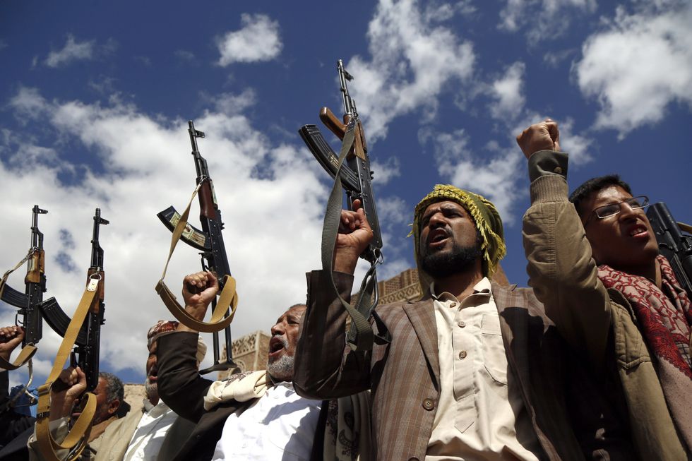 Houthi followers hold their guns during a tribal gathering