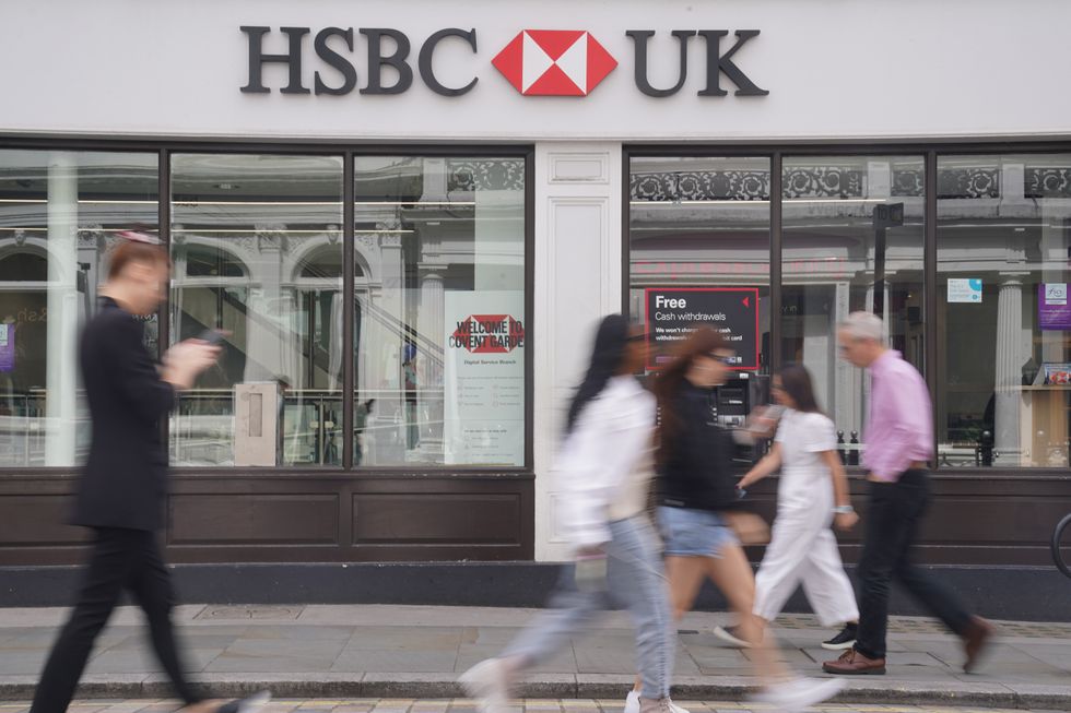 HSBC UK sign outside bank branch with people walking past on street