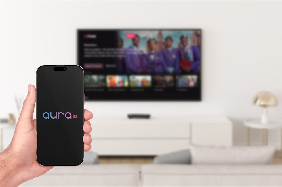 Humax Aura EZ logo shown on a smartphone screen with the living room in the background