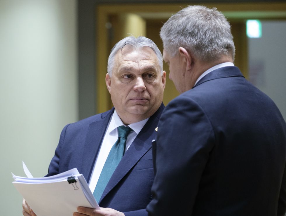 Hungarian Prime Minister Viktor Mihaly Orban (Front) talks with Slovak Prime Minister Robert Fico (Back) prior to the start of an EU Summit