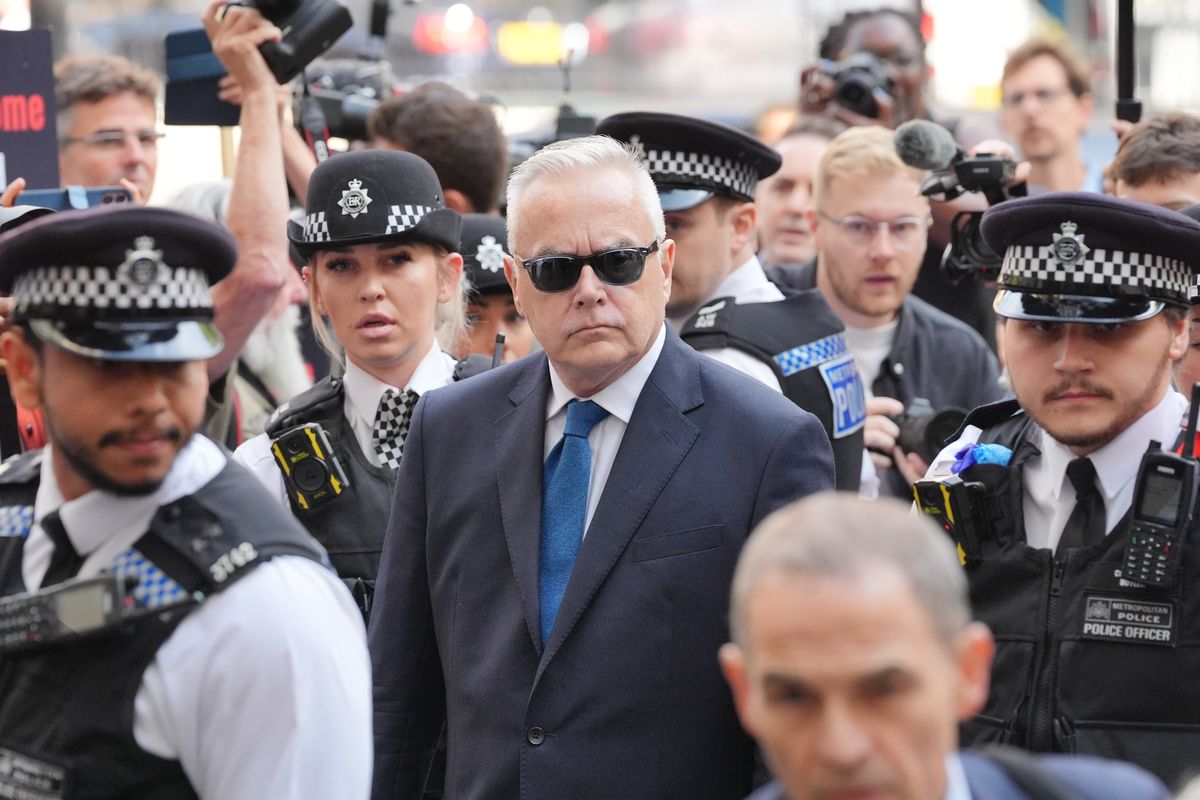 Huw Edwards was flanked by police as he made his way into court