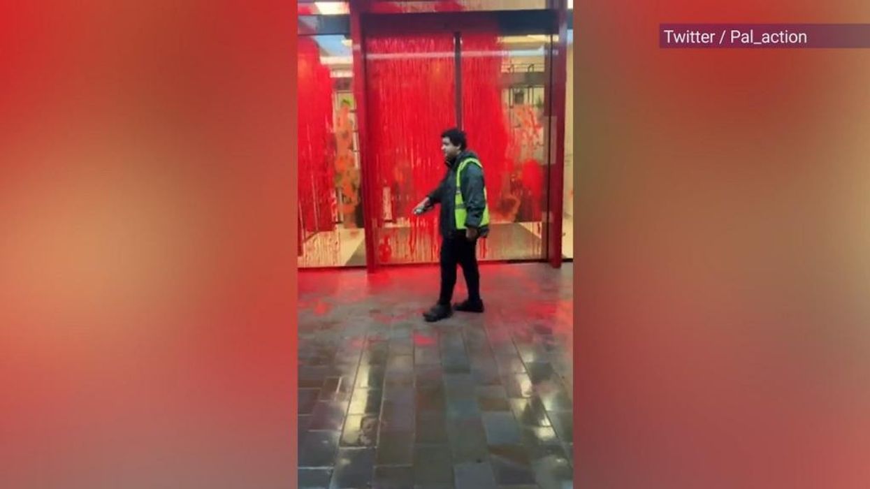 Palestine activists hurl red paint over London building and climb onto entrance roof