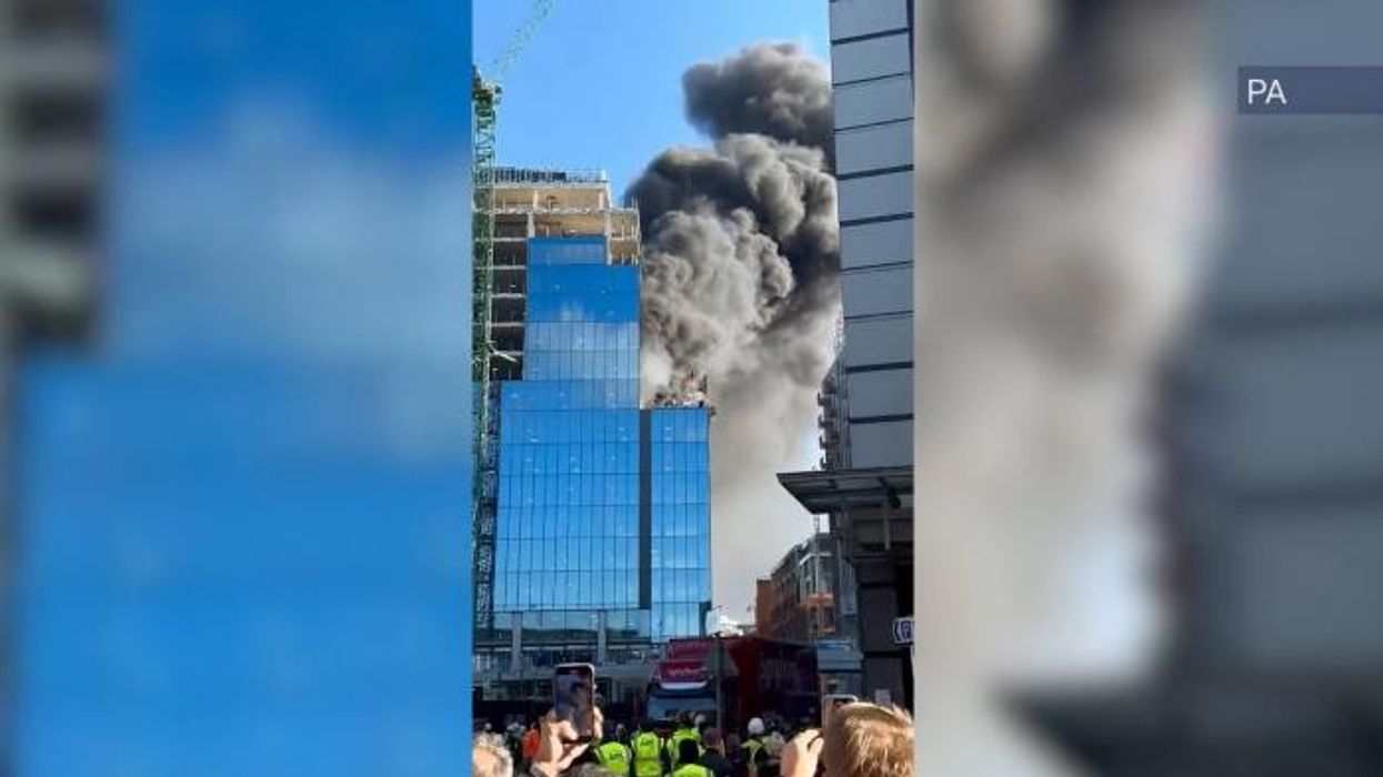 Reading fire: Thick black smoke engulfs sky as firefighters use a CRANE to rescue man trapped on top of blazing building