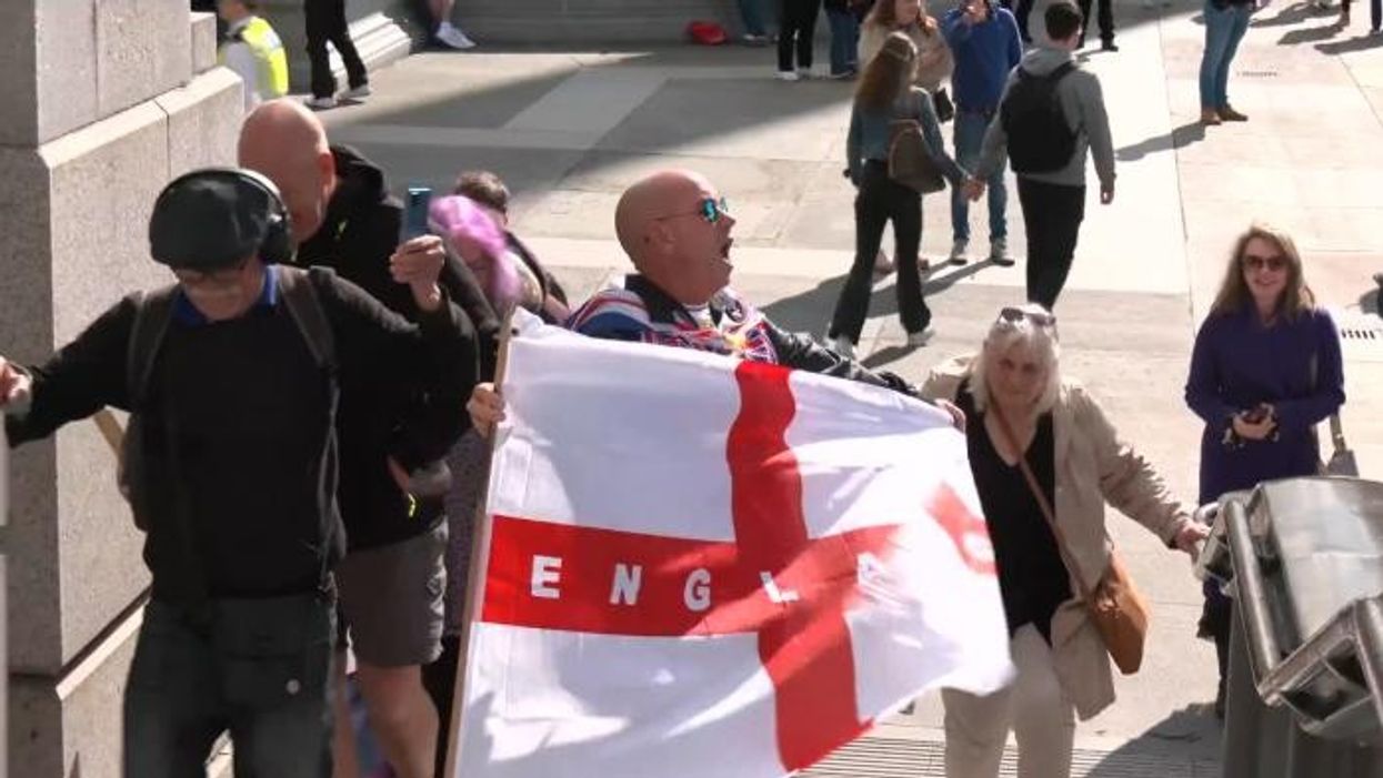 Stand Up To Racism protestor grabs St George's flag at Trafalgar Square demonstration