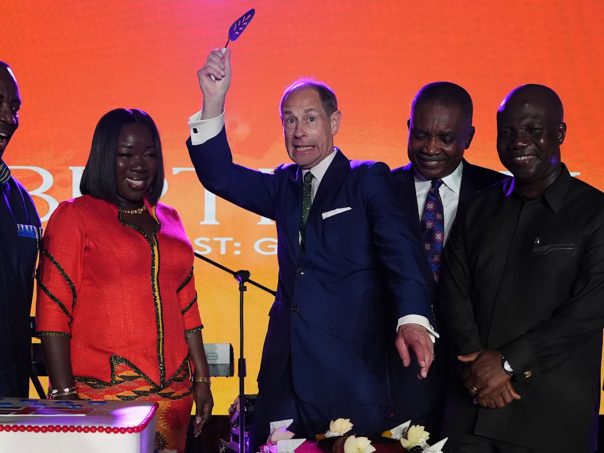 Prince Edward waves knife above his head in flamboyant cake cutting ceremony