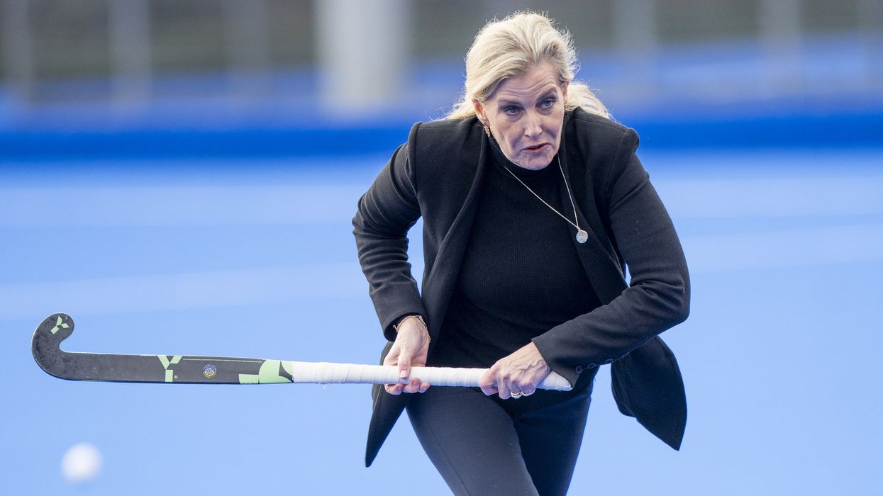 Duchess of Edinburgh wallops hockey balls while wearing a blazer during royal engagement