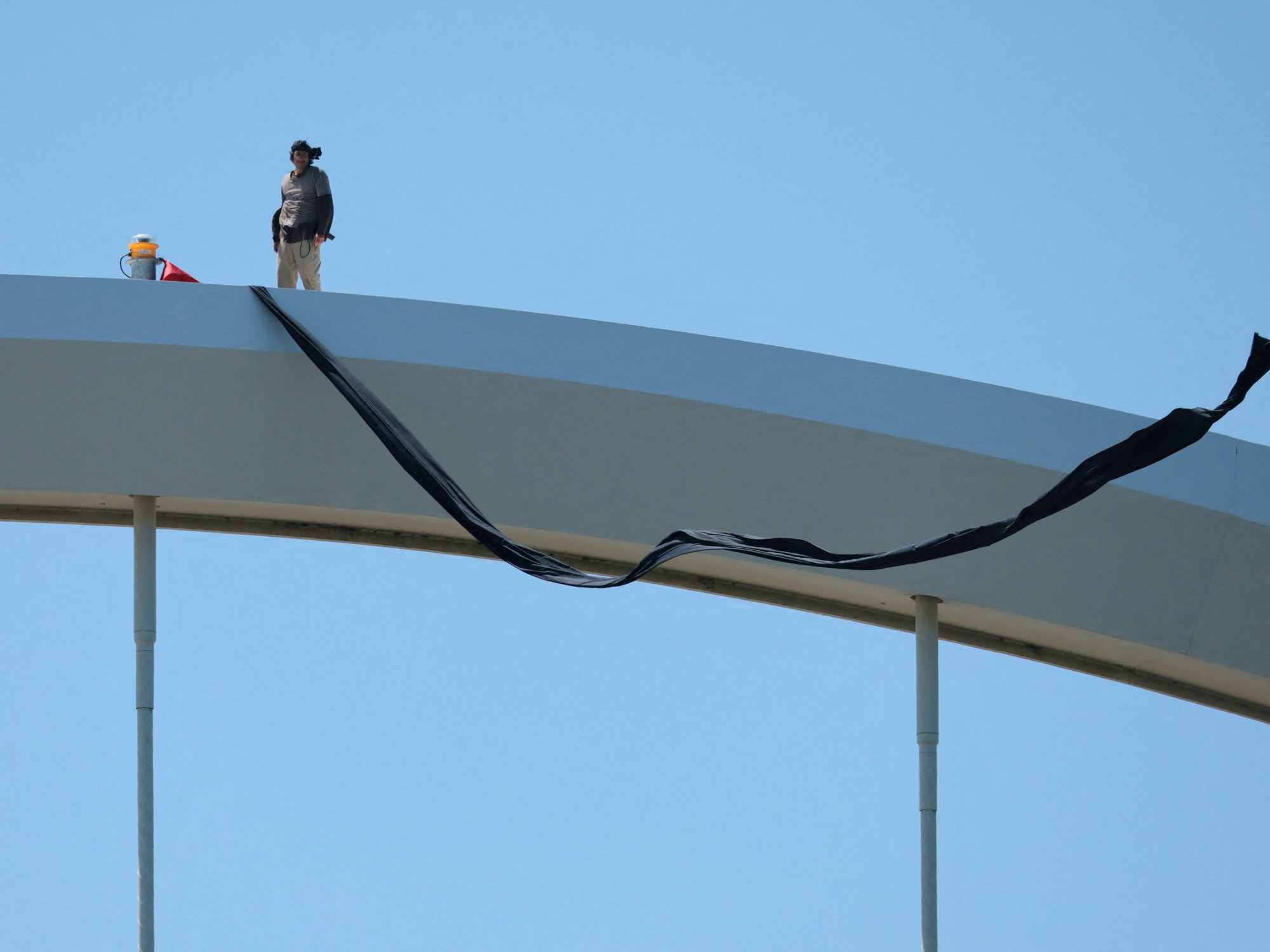 Anti-Iran war activist STILL atop iconic Washington bridge demanding revolution after saying he w...