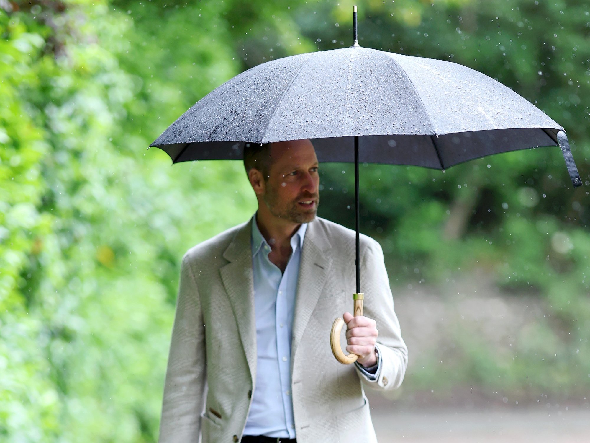 Prince William braves the rain to shine spotlight on projects funded by his and Catherine's foundation