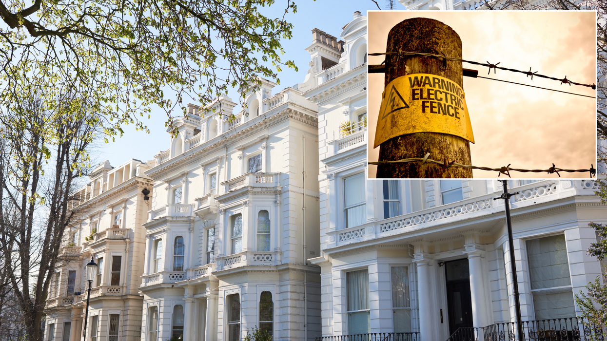 Council clashes with millionaire who erected electric fence around mansion that looks like 'POW camp'