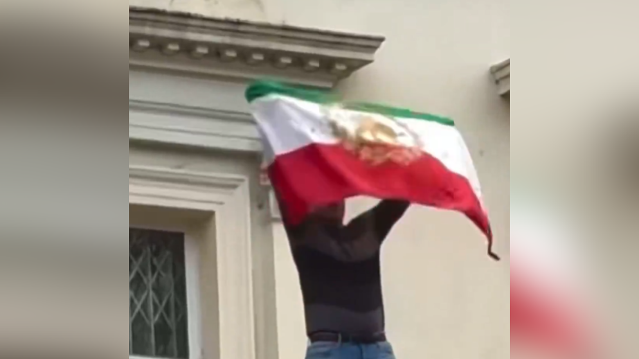 Protester rips flag off Iranian Embassy in London as demonstrations reach Britain