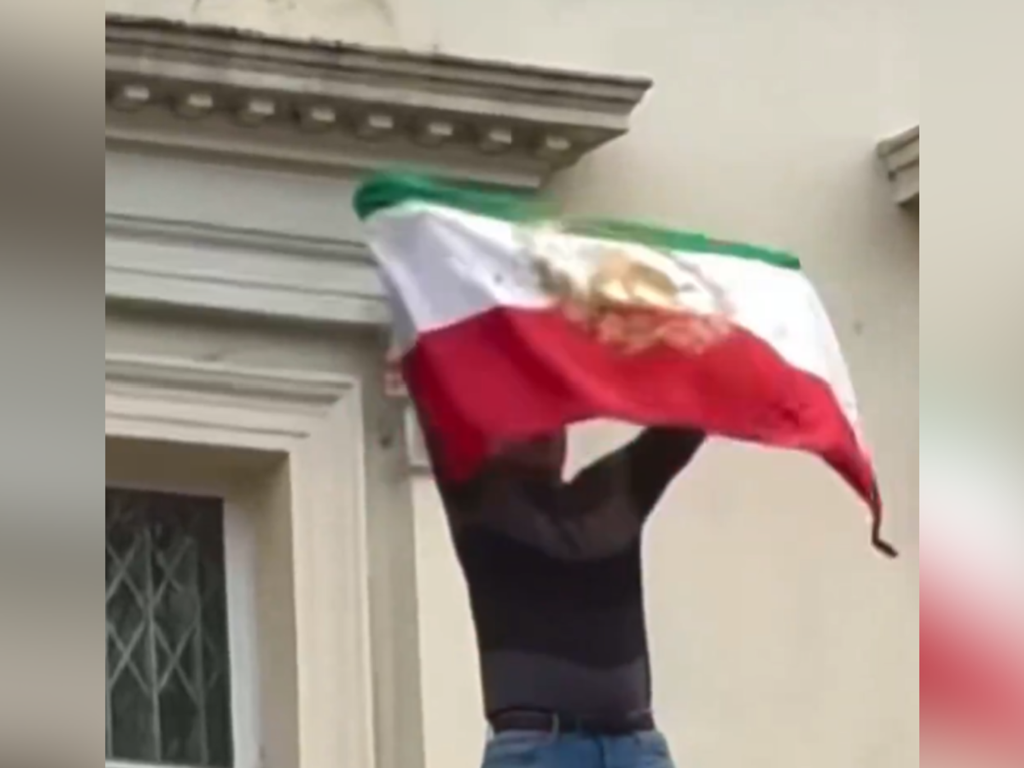 Protester rips flag off Iranian Embassy in London as demonstrations against Supreme Leader go worldwide