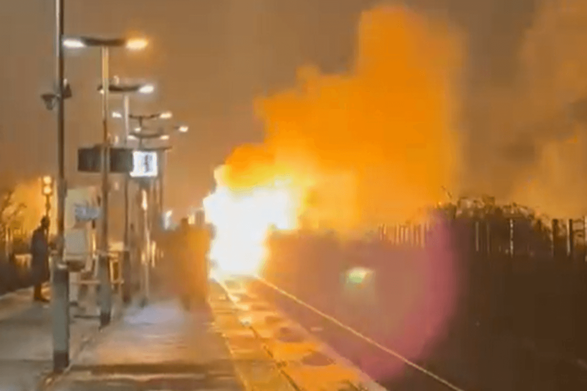 Flames erupt and black smoke fills night sky in huge blaze on train line