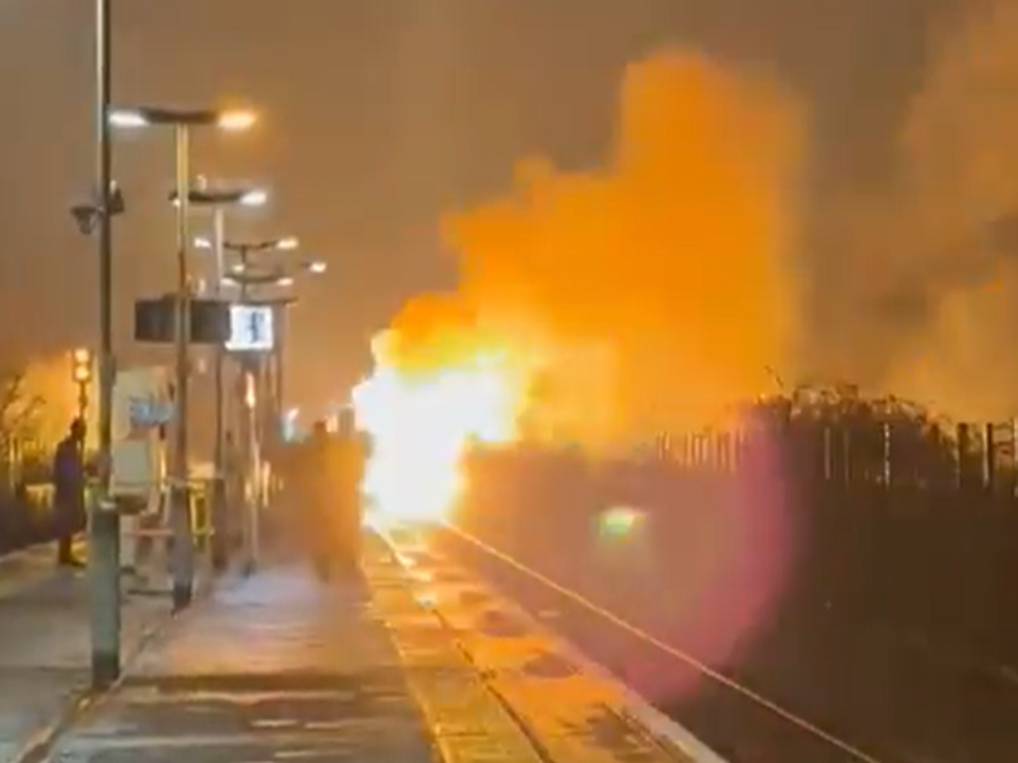 Flames erupt and black smoke fills night sky in huge blaze on train line