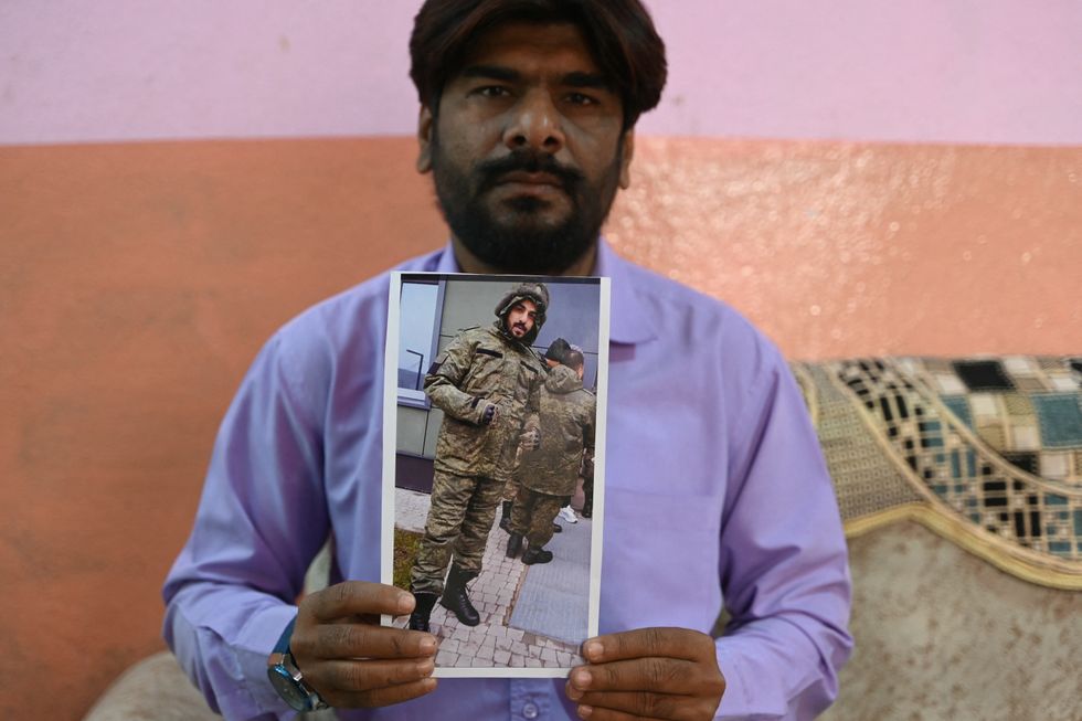 Imran Asfan holds up a picture of his brother Mohammed who died while fighting in Ukraine