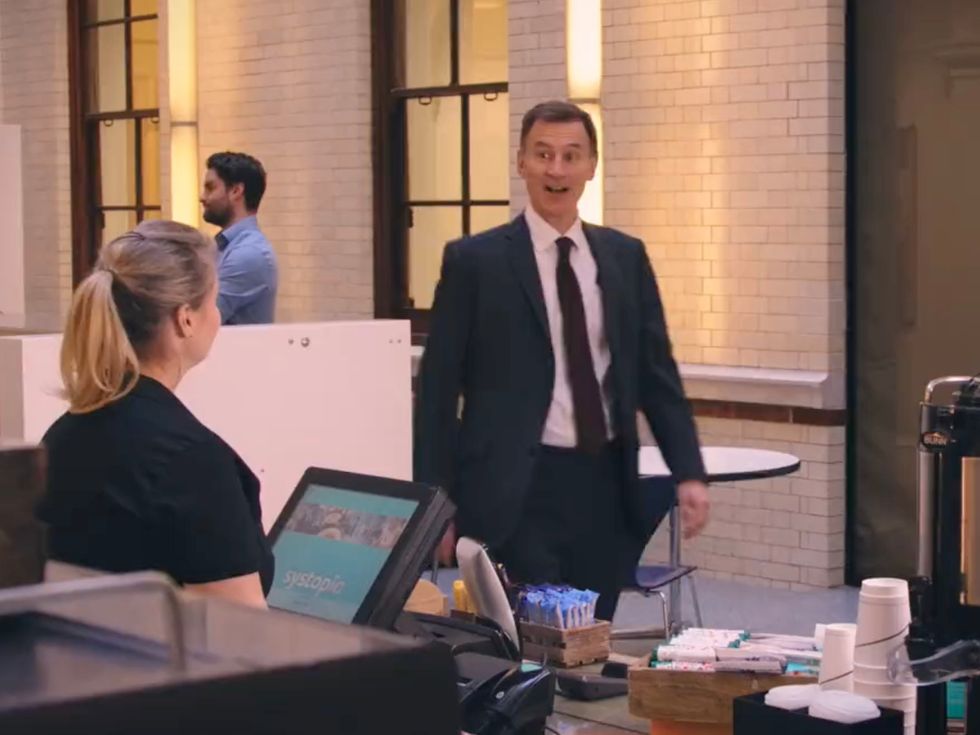 In the video he orders a flat white and holds two coffee cups, one labelled \u00a32.56 and the other \u00a32.86.