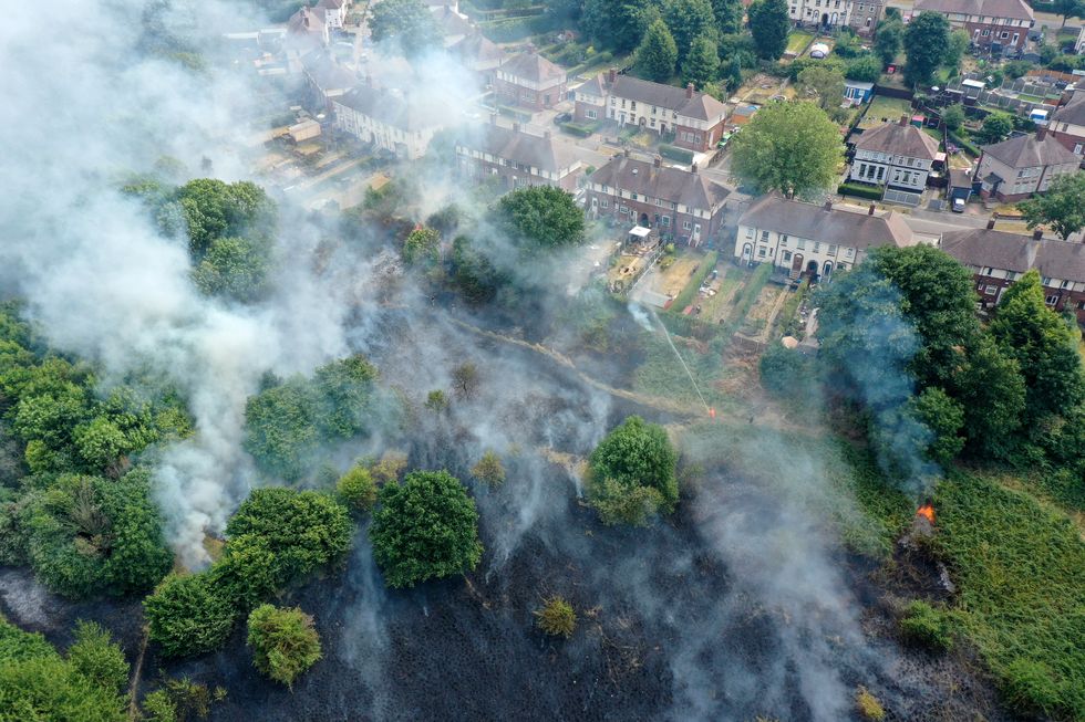 In this aerial view Firefighters contain a wildfire that encroached on nearby homes in the Shiregreen area of Sheffield