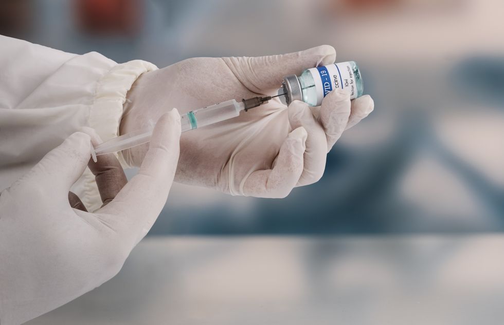 Injection being held by a medic with white gloves
