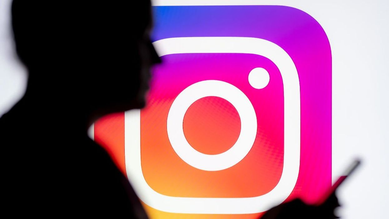 Instagram logo with shadow of person in front holding phone