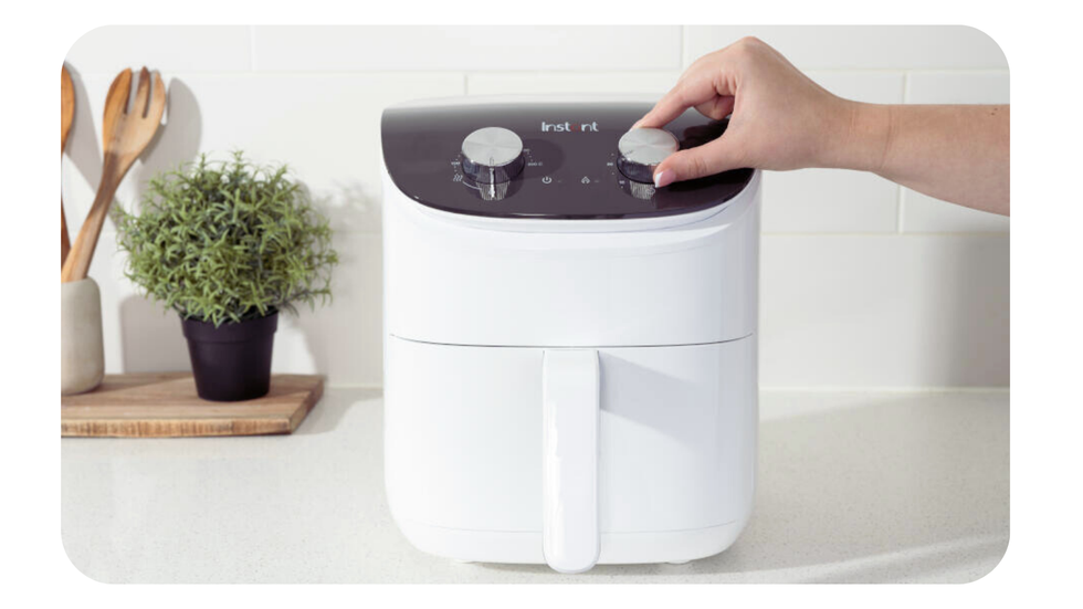 instant air fryer with 3.8-litre capacity pictured on a kitchen worktop with a hand adjusting the temperature settings