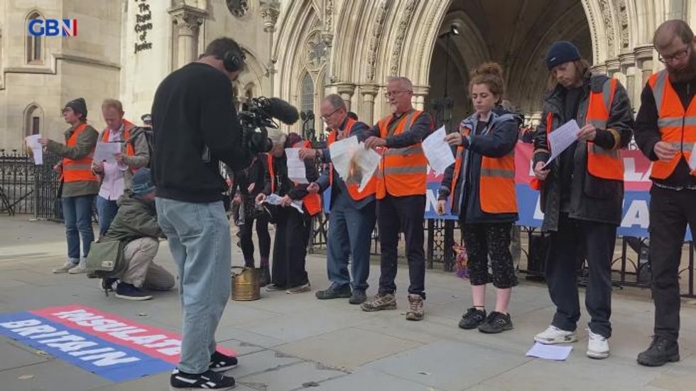 Insulate Britain protesters set light to court injunction papers outside Royal Courts of Justice in London