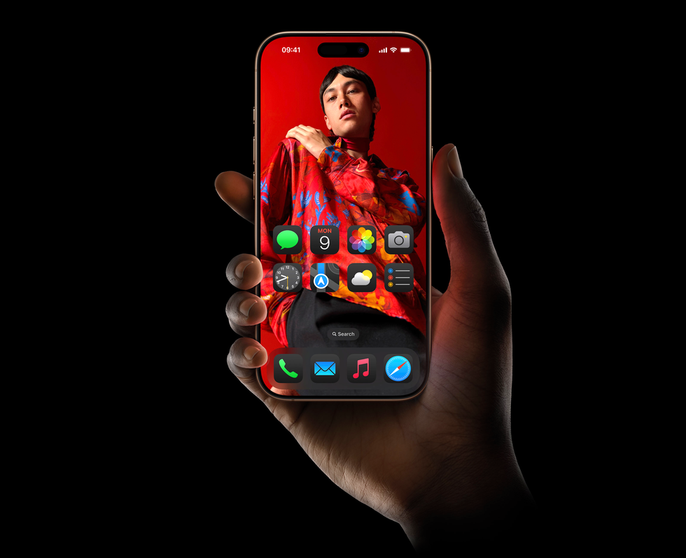 iphone 16 pro with red wallpaper pictured in someones hand