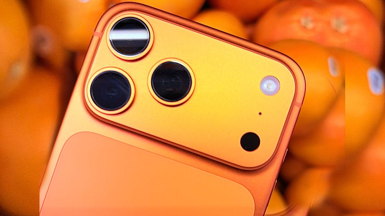 iPhone 17 Pro in Cosmic Orange with some oranges behind it