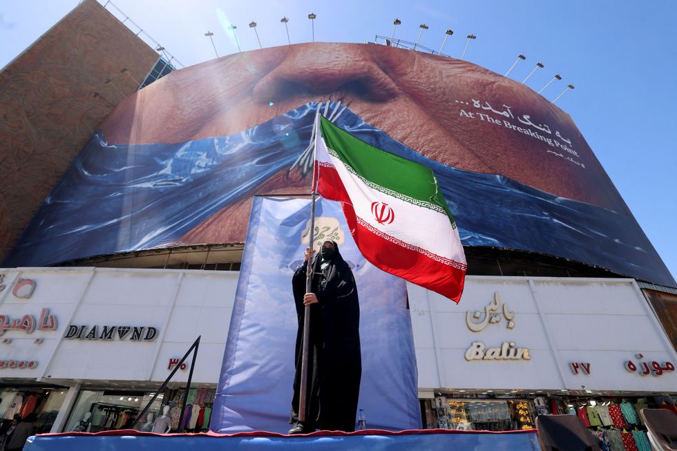 Iranian woman holds an Iranian flag