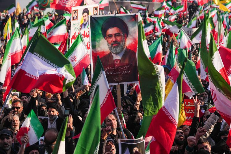 Iranians holding posters bearing portraits of assassinated Ali Khamenei and of his son, Mojtaba Khamenei