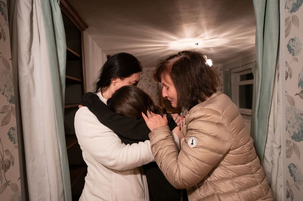 Iryna Starkova comforts her daughter Valeriia (left) and granddaughter Kamila at their new home in Caldecote near Cambridge. The family of ten who range in age from Alikhan, aged 10, to 90-year-old great grandmother Ludmila, fled Kharkiv in the Ukraine following the Russian invasion, beginning their journeys on March 1. They have been helped by Rend Platings to find a new home in the UK for them and their two dogs Mikki and Florie. Picture date: Tuesday March 22, 2022.