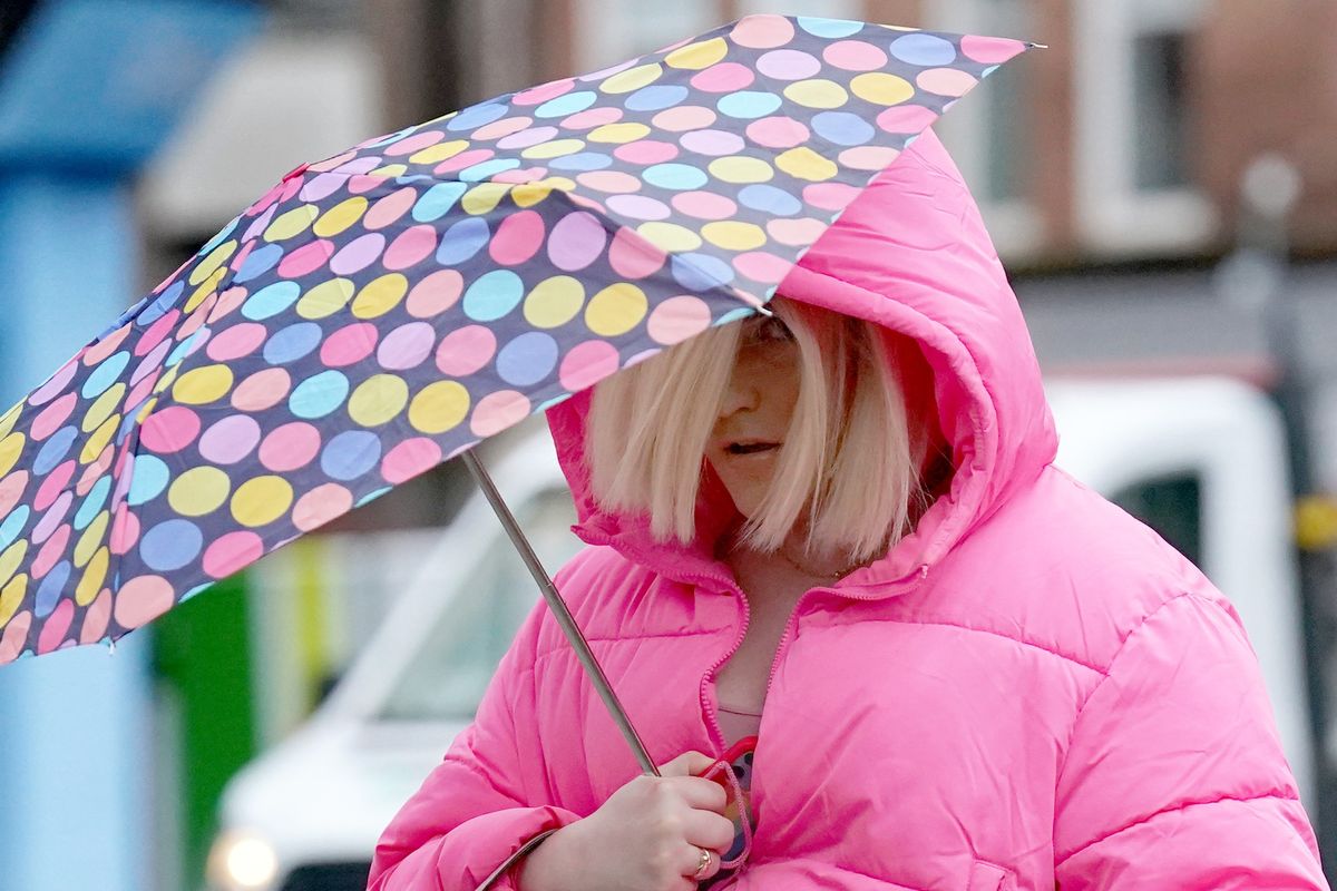 Isla Bryson walking with an umbrella 