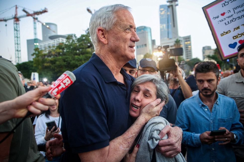 Israel war cabinet member Benny Gantz embraces a woman as he walks to meet with hostages family members