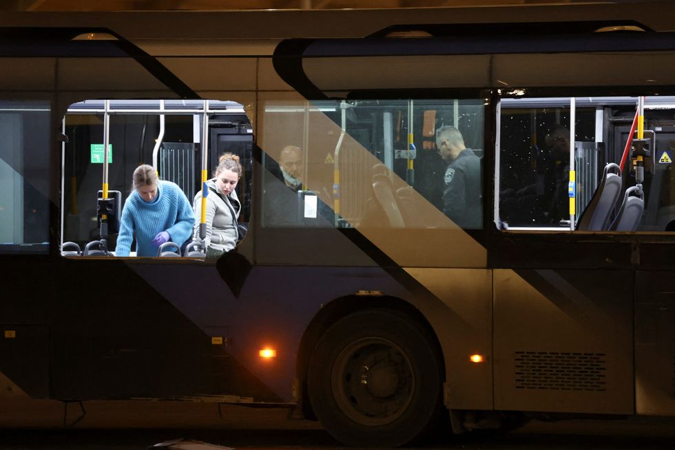 Israeli authorities sweep a bus in Tel Aviv after the explosions