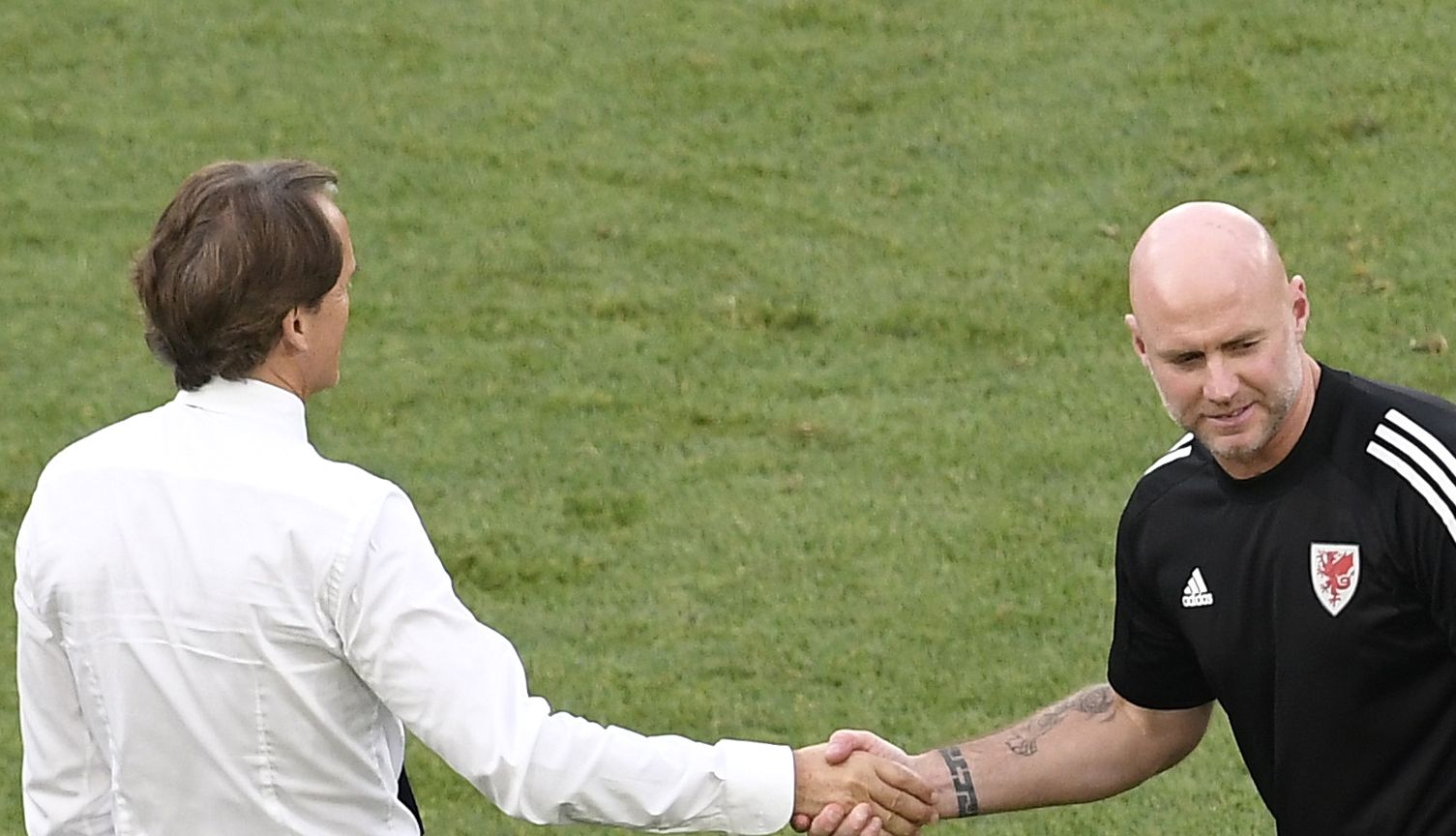 Italy manager Roberto Mancini greets Wales caretaker manager Rob Page after the final whistle.