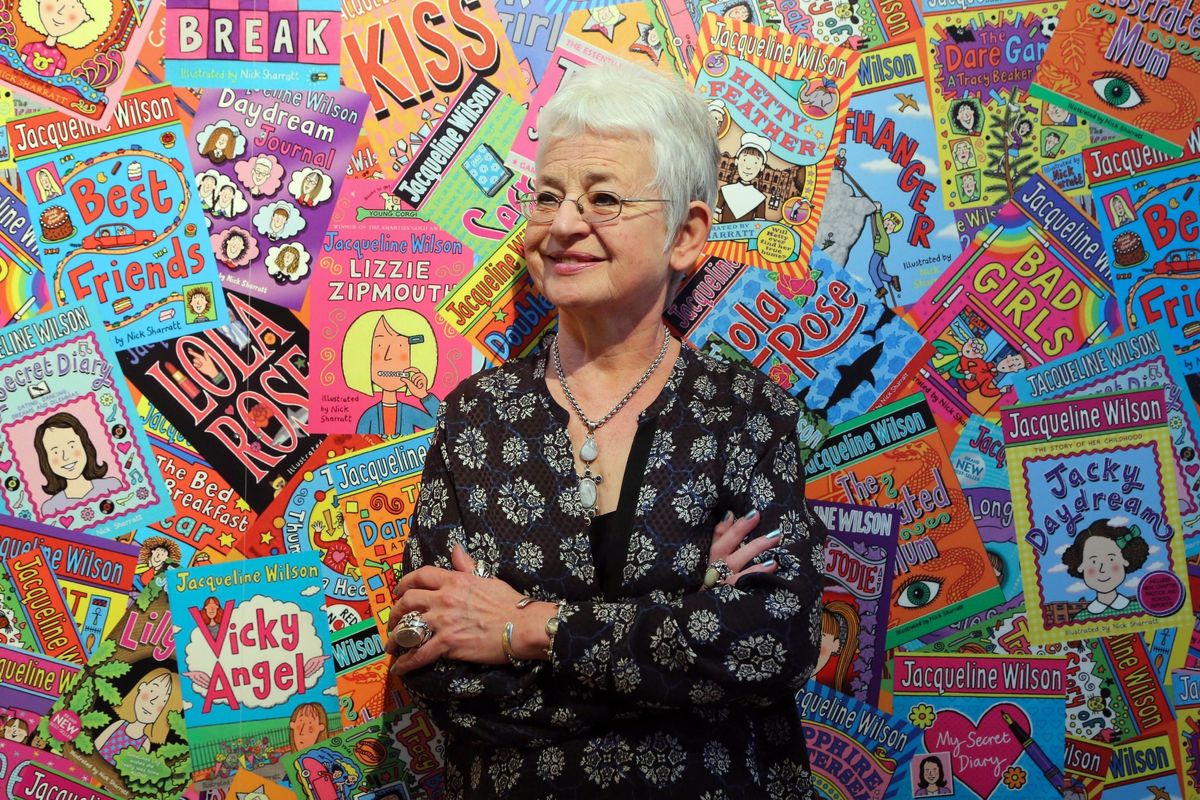 Jacqueline Wilson in front of a backdrop featuring her books 