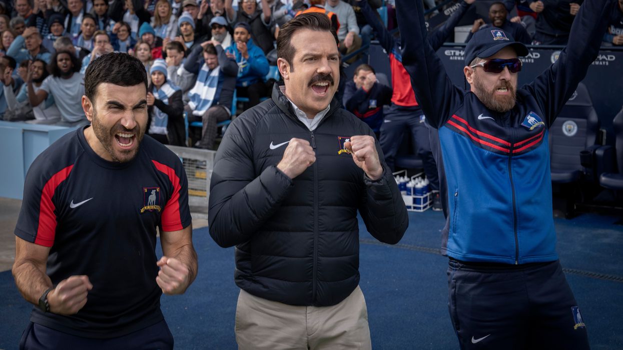 Jason Sudeikis in character as Ted Lasso, celebrating a victory on the side of the football pitch in the latest season of the comedy series
