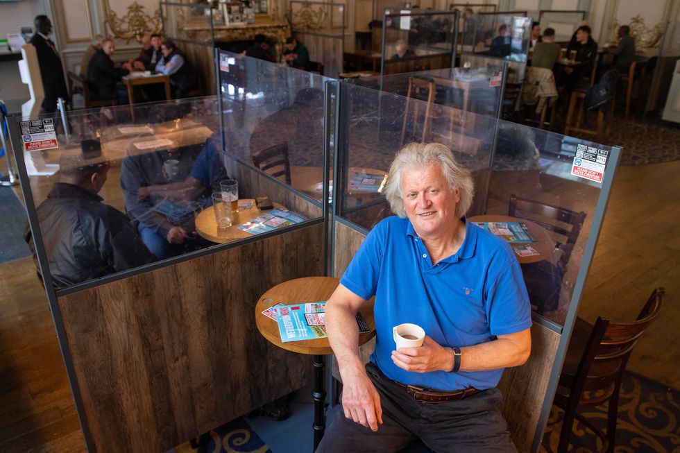 JD Wetherspoon founder and chairman Tim Martin in a pub holding coffee mug