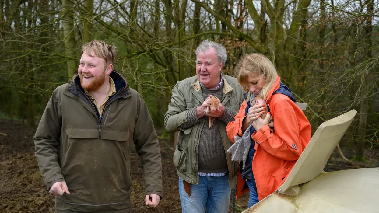 Jeremy Clarkson, Lisa Hogan, and Kaleb Cooper pictured holding piglets in clarksons farm 3 series