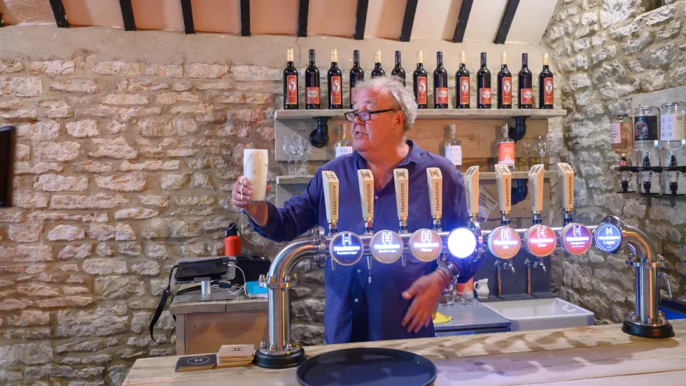 Jeremy Clarkson pictured holding up a pint of Hawkstone lager in his pub, The Farmers Dog