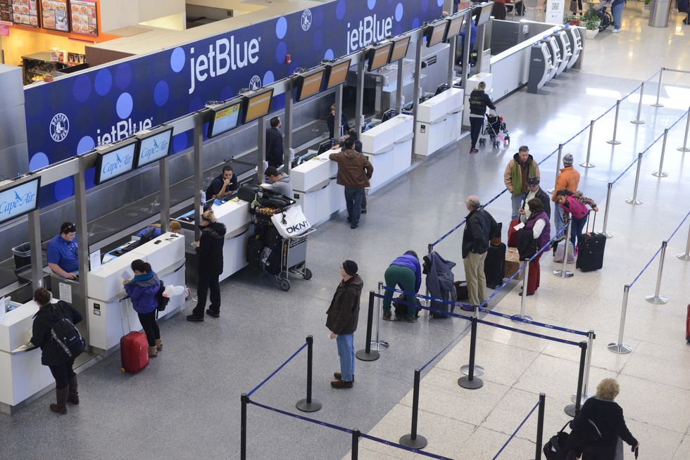 JetBlue passengers stand in thin lines while waiting for normal flights to resume