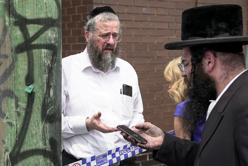 Jewish community members gather at the scene of a fire at the Adass Israel Synagogue