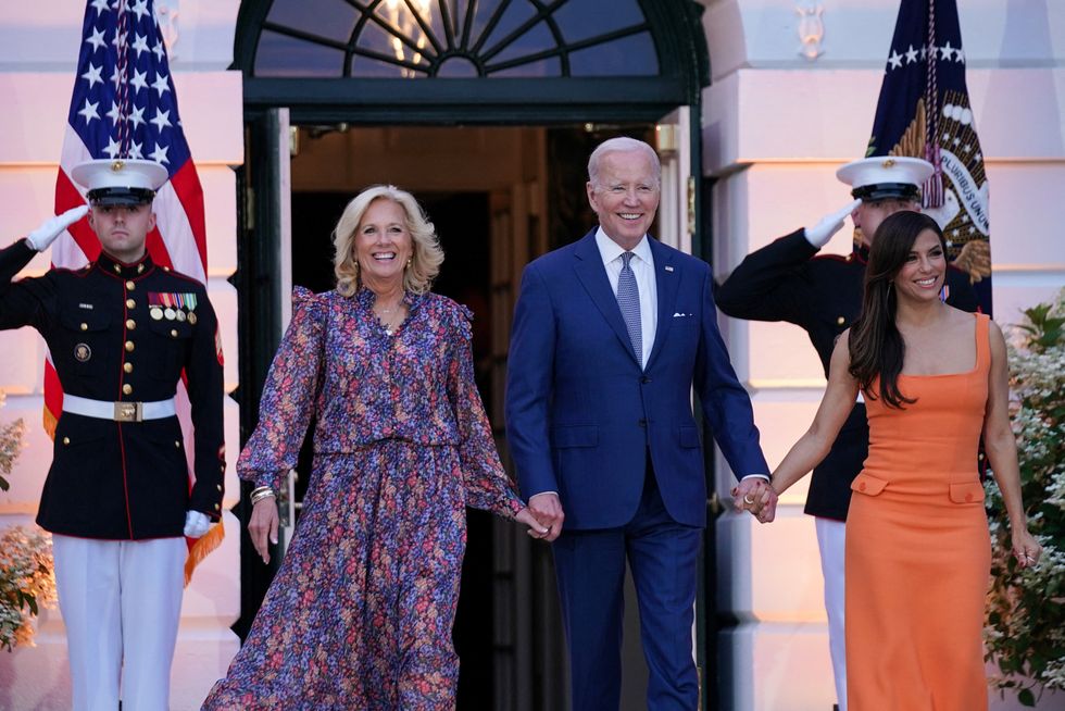 Jill and Joe biden walk hand in hand with Longeria