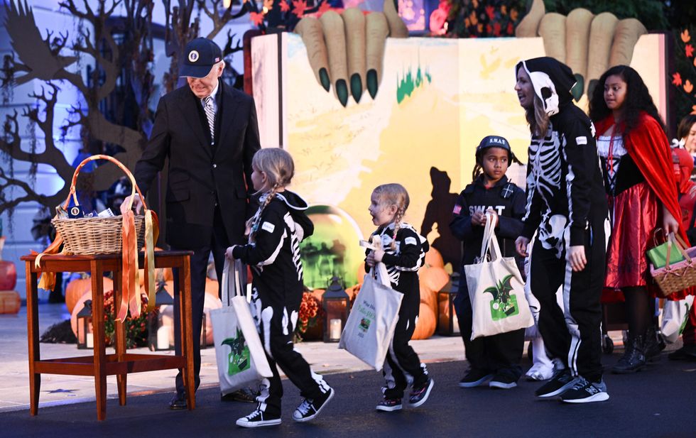 Joe Biden hands out candy to children during a Halloween celebration on the South Lawn of the White House