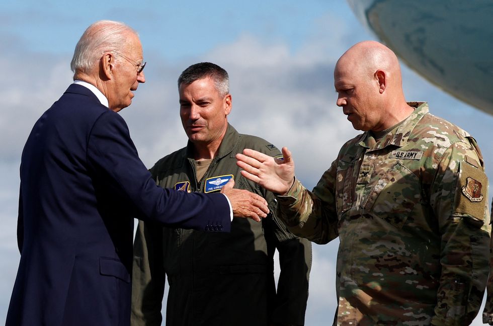 Joe Biden speaks with service members before boarding Air Force One, on the day of the 22nd anniversary of the September 11, 2001 attacks on the World Trade Center